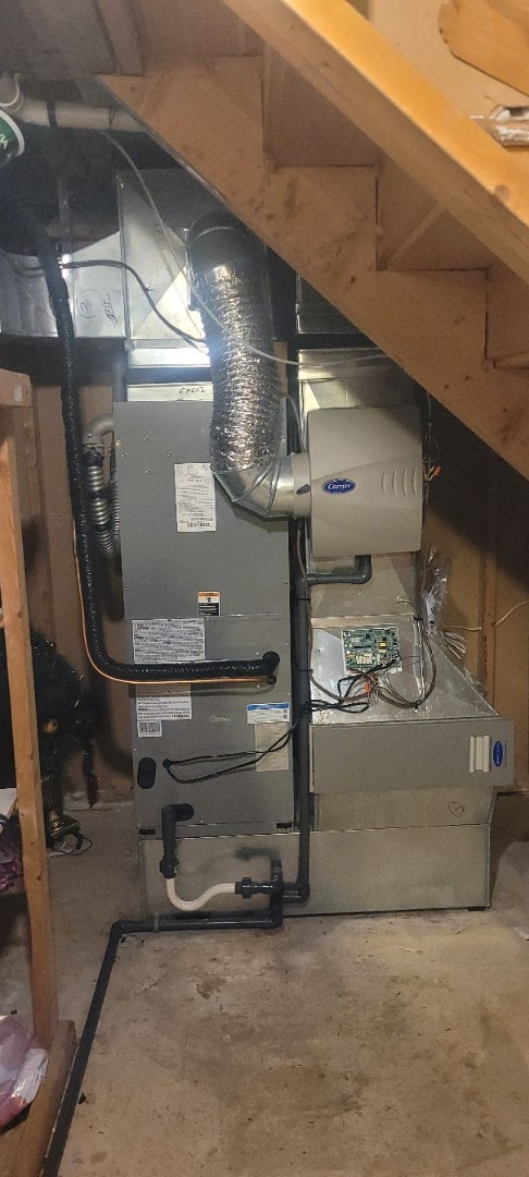 Un système de chauffage central avec conduits en métal et tuyaux isolés dans un sous-sol.