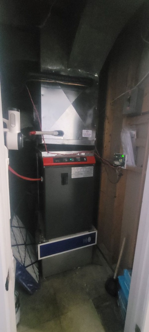Un système de chauffage central avec conduits en métal et tuyaux isolés dans un sous-sol.