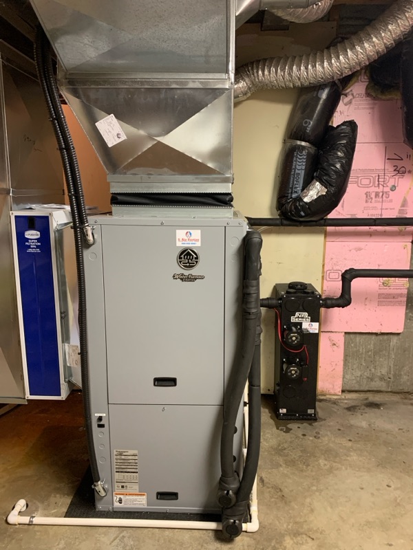 Un système de chauffage central avec conduits en métal et tuyaux isolés dans un sous-sol.