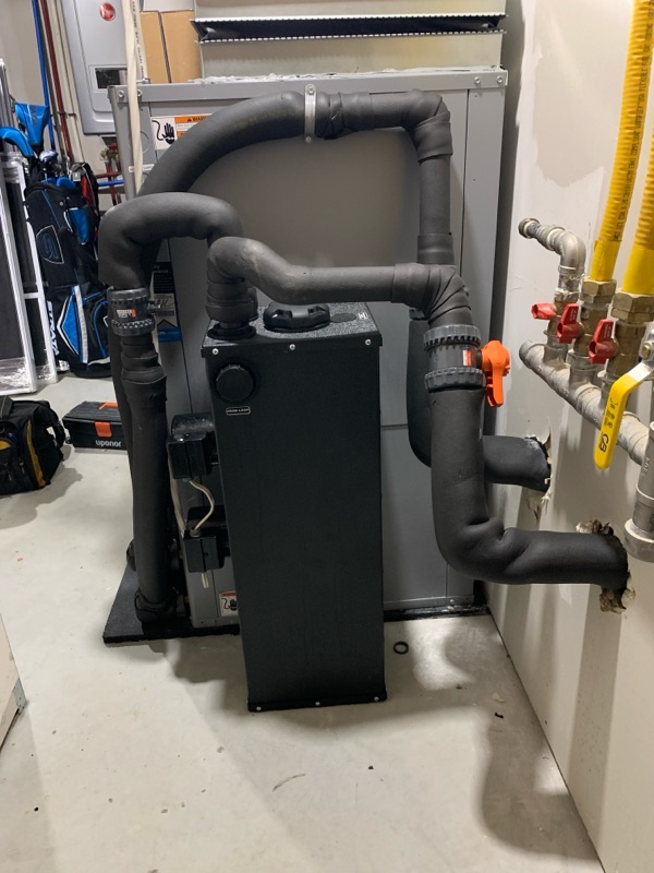 Un système de chauffage central avec conduits en métal et tuyaux isolés dans un sous-sol.