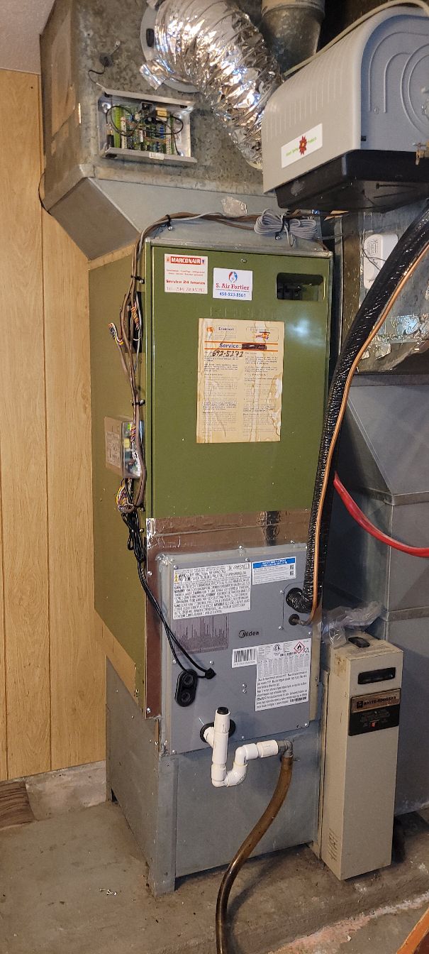 Un système de chauffage central avec conduits en métal et tuyaux isolés dans un sous-sol.