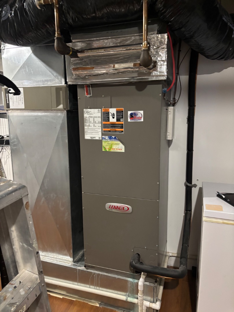 Un système de chauffage central avec conduits en métal et tuyaux isolés dans un sous-sol.