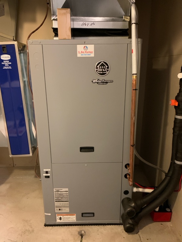 Un système de chauffage central avec conduits en métal et tuyaux isolés dans un sous-sol.