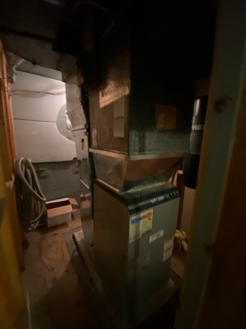 Un système de chauffage central avec conduits en métal et tuyaux isolés dans un sous-sol.