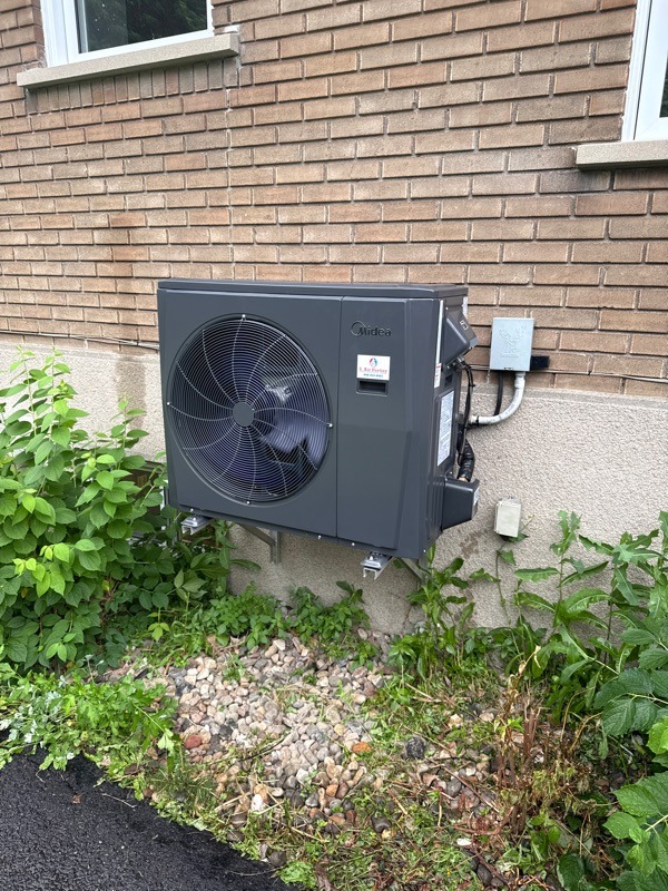 Un système de chauffage central avec conduits en métal et tuyaux isolés dans un sous-sol.
