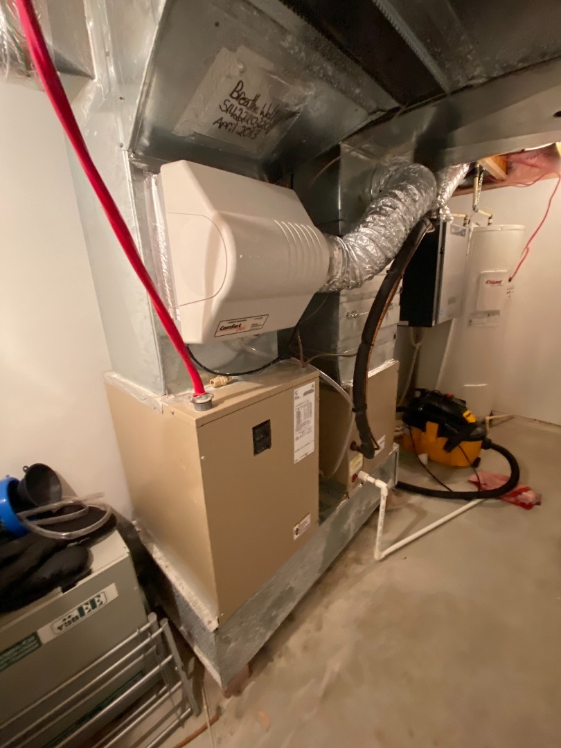 Un système de chauffage central avec conduits en métal et tuyaux isolés dans un sous-sol.