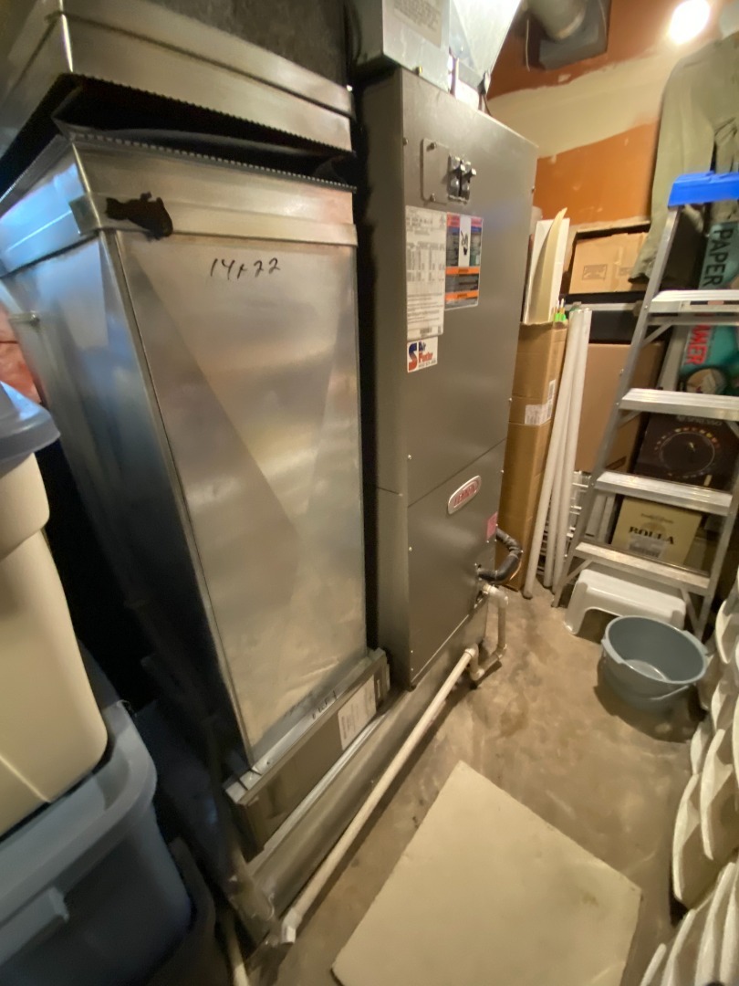 Un système de chauffage central avec conduits en métal et tuyaux isolés dans un sous-sol.